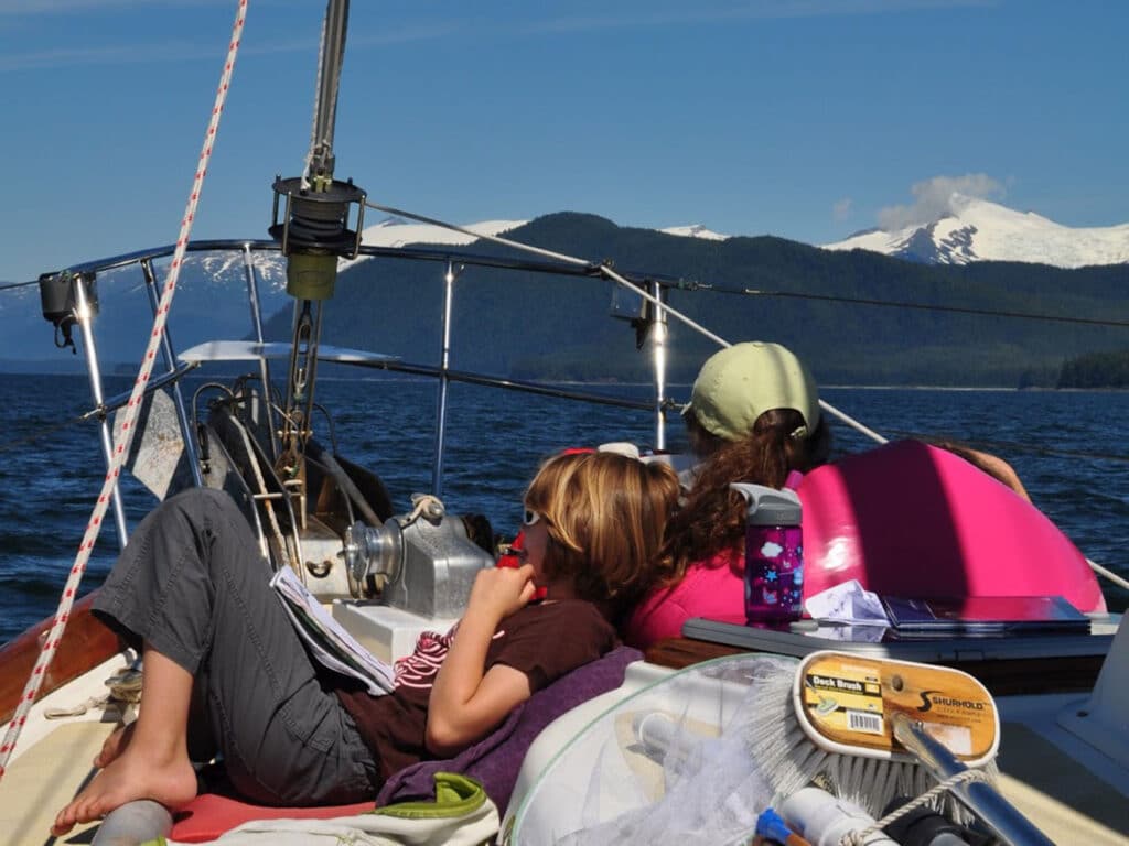 Kids on the front of a sailboat