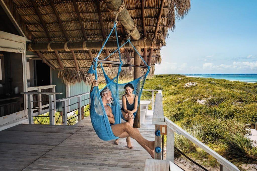 A couple relaxing in hammocks.