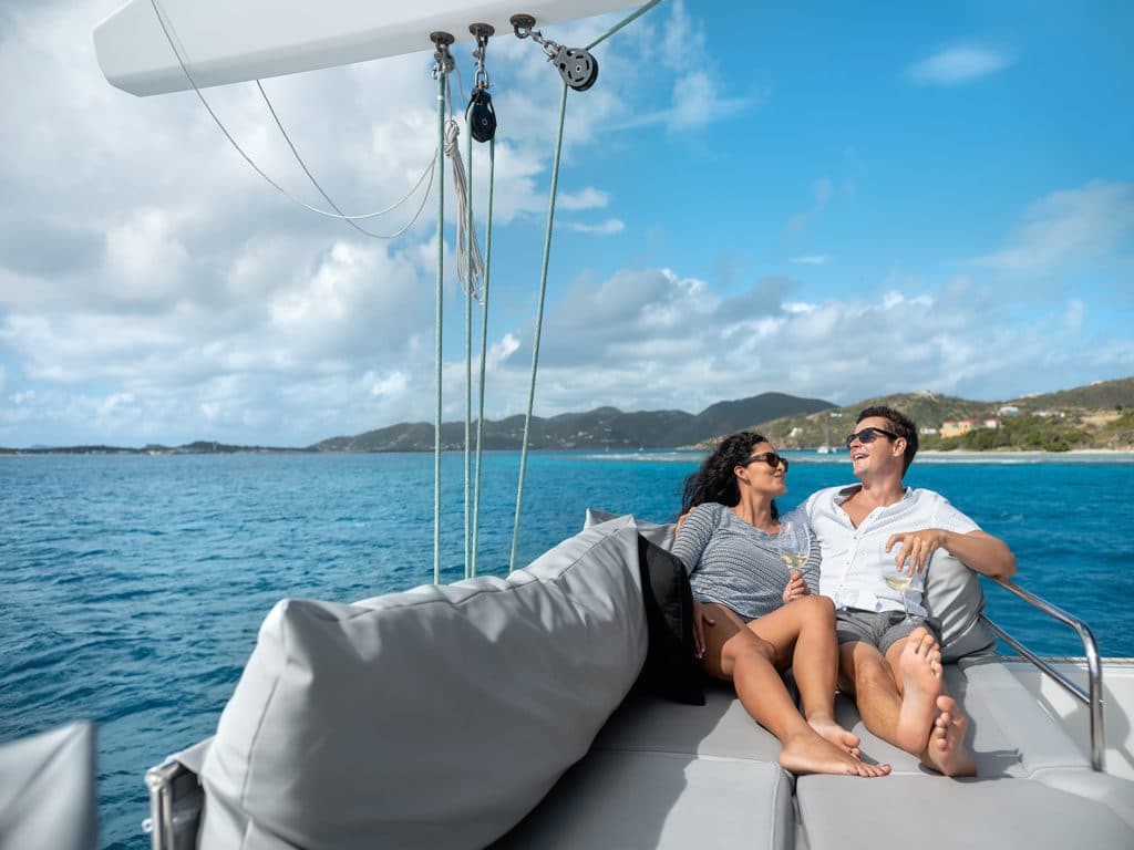 A couple reclining on a catamaran.