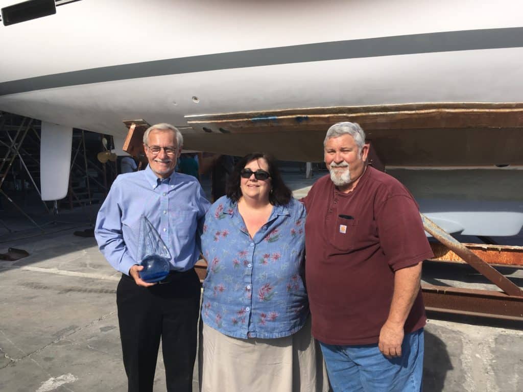 *Cruising World* publisher Sally Helme presents the Boat of the Year trophy to Gerry Douglas (left).