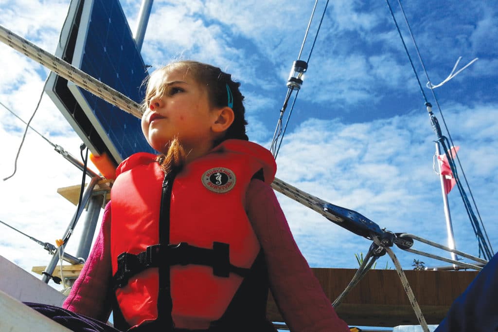 young girl helming a sailboat