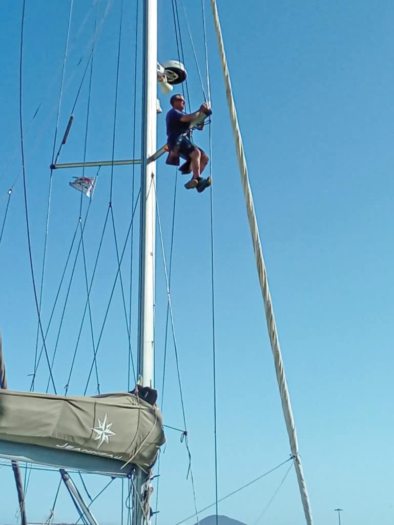 Sailor checking the rigging on a boat.