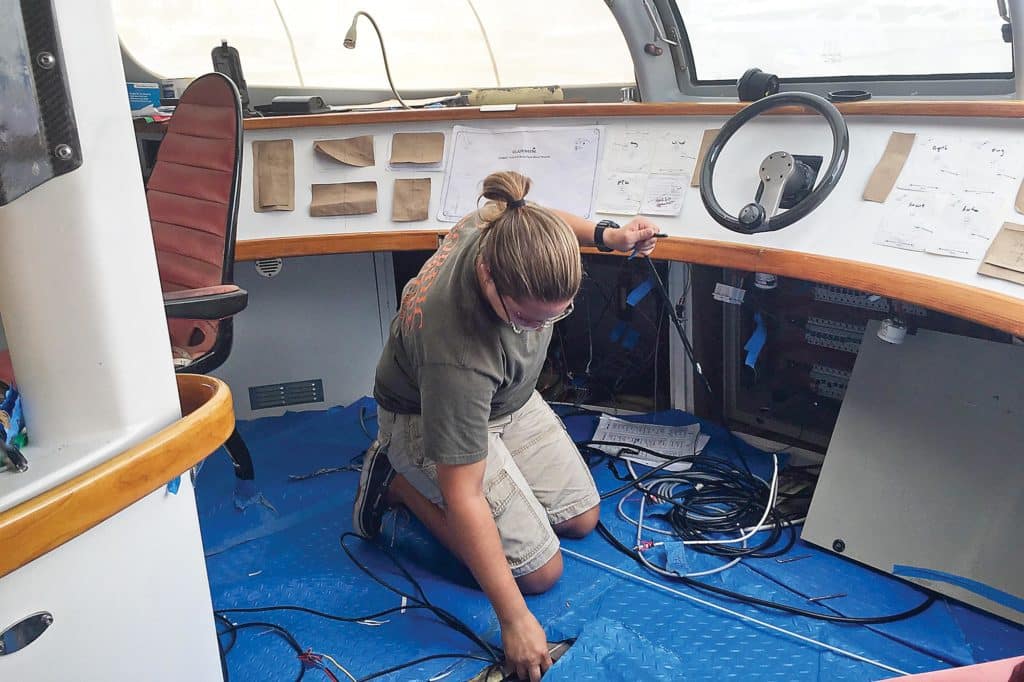 A technician working on sailboat electronics wiring.