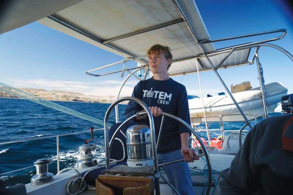Young man steering a sailboat