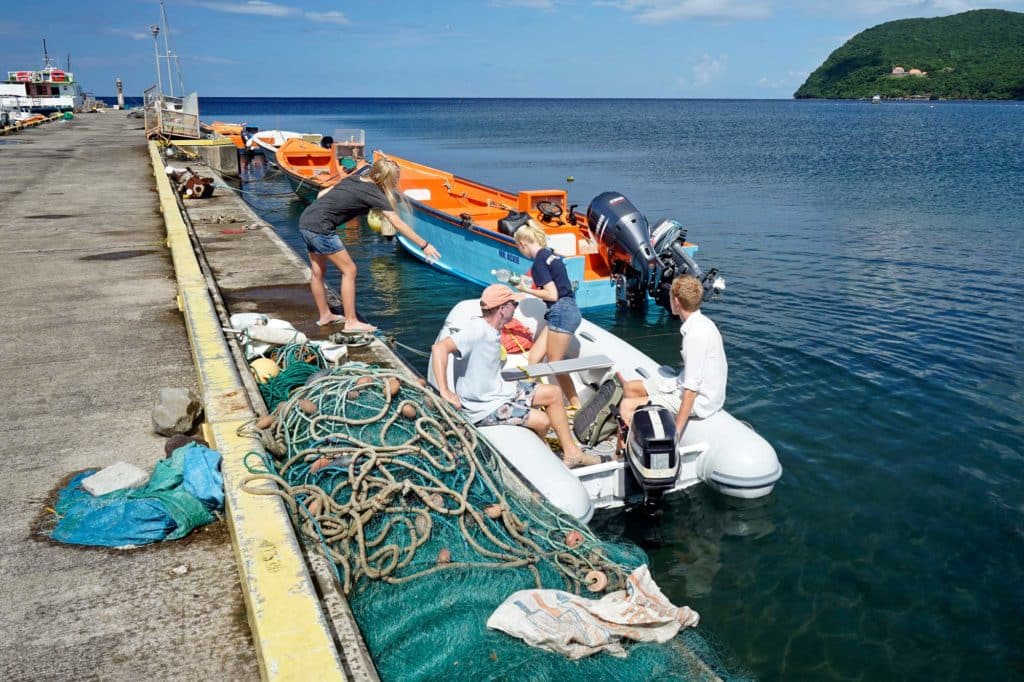 people in a dinghy next to a dock