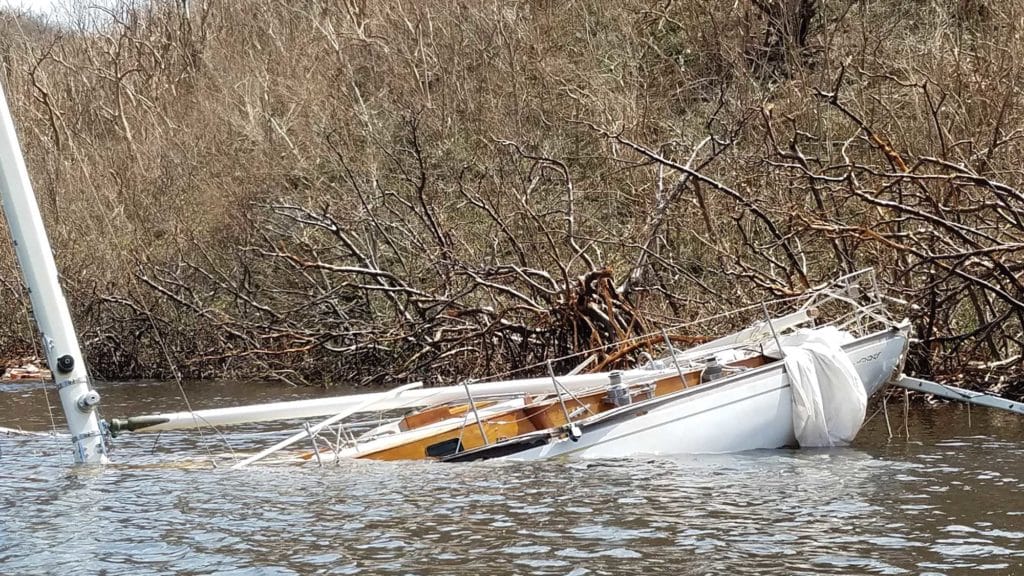 sailboat submerged on a shorline
