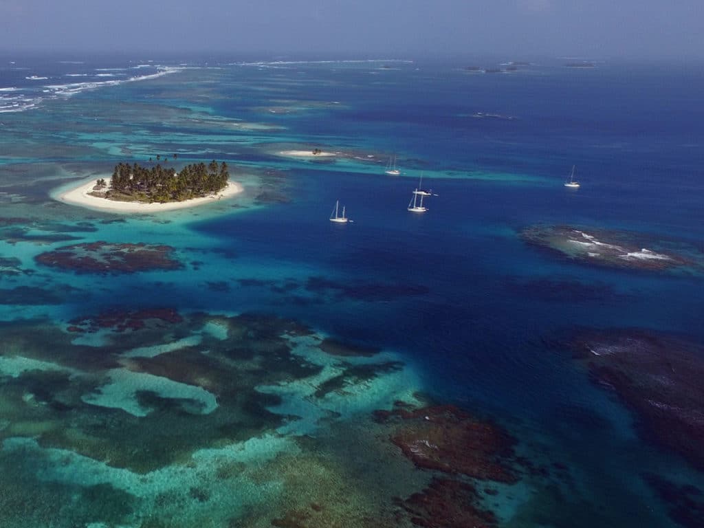 sailboats anchored off deserted island