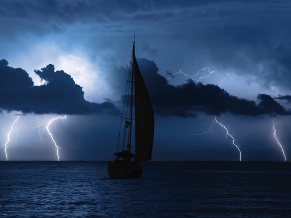 Sailboat at sea with storm in background
