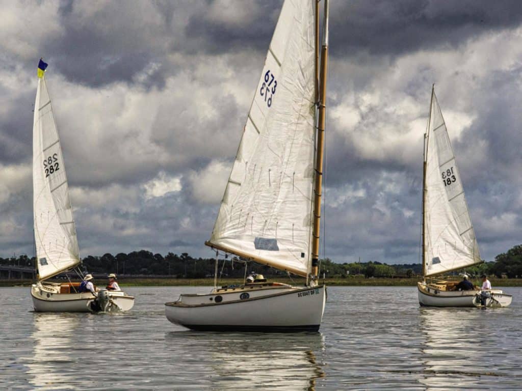 three sailboats in the calms