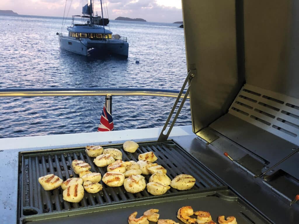 shrimp and scallops being grilled on a boat