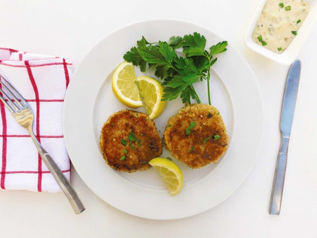 Crab cakes with lemon wedges on a serving plate
