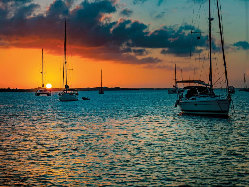 Sailboats at sundown anchor in Elizabeth Harbor in the Bahamas