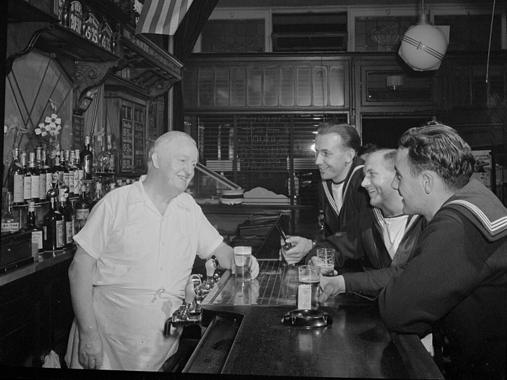 Sailors at a bar talking to the bartender