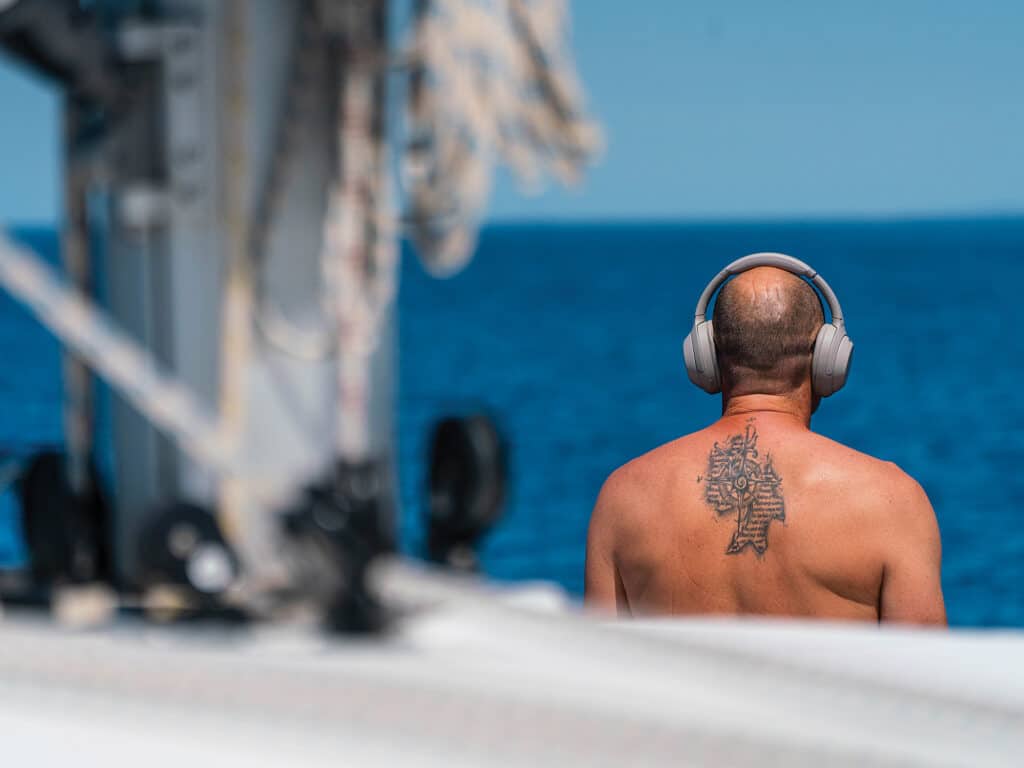 Man on sailboat with headphones on