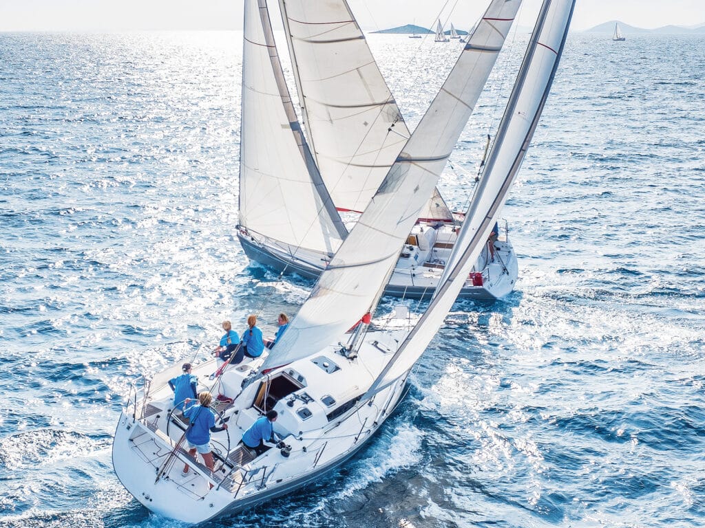 Sailing boats from bird view crossing open sea