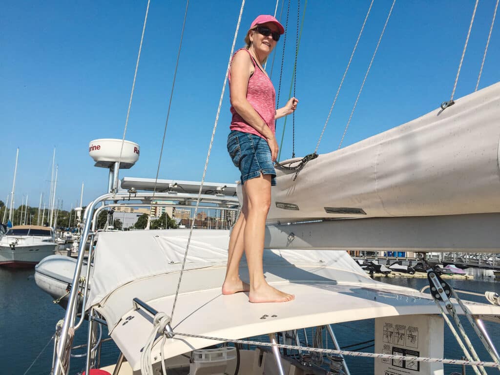 Lorelei Johnson adjusts sail cover on Sasha