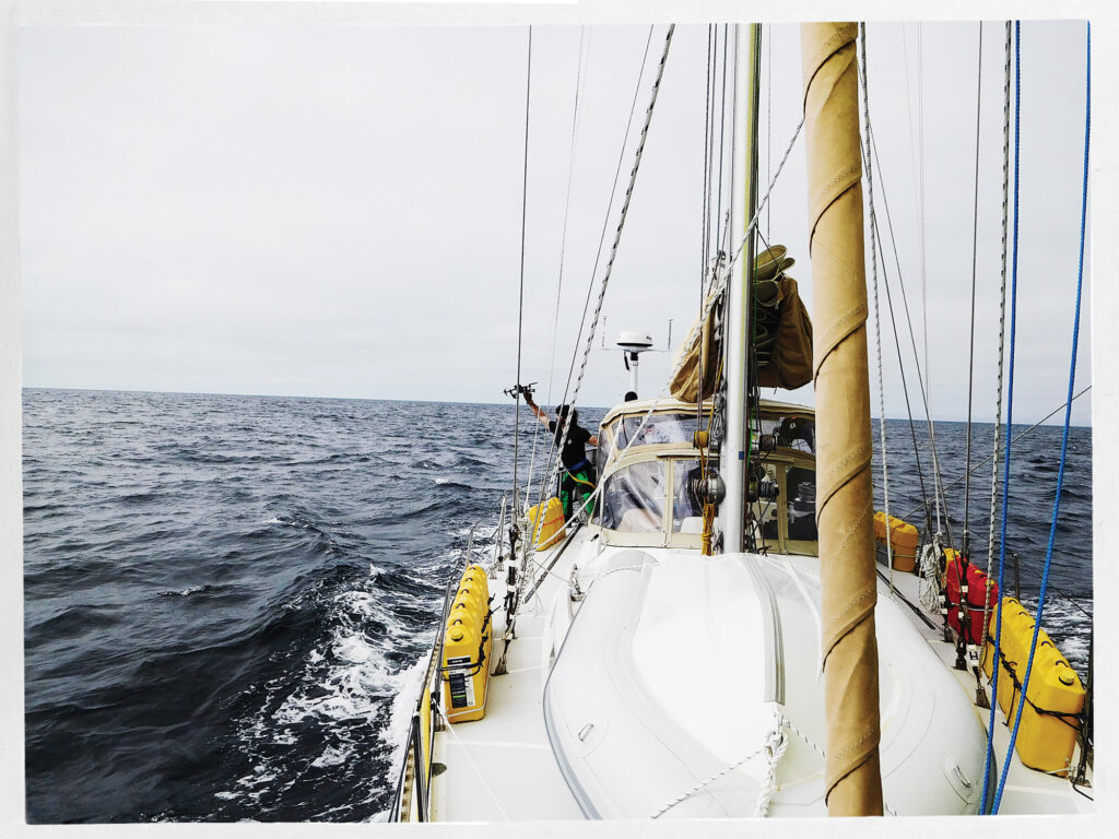 Man retrieving camera drone on a sailboat