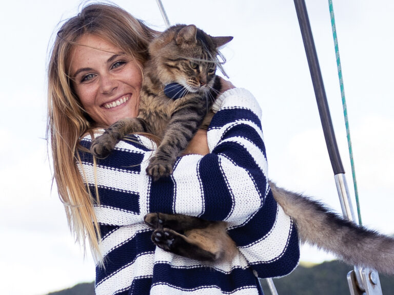 Woman holding a cat on a sailboat