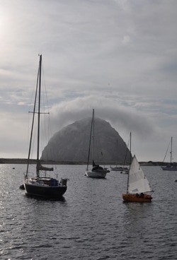 Del Viento- Morro Bay Windy sailing the Portland Pudgy through the mooring field in front of Morro Rock. At only 581 feet, it may be an unfair comparison, but I think of this as the Gibraltar of the West Coast.