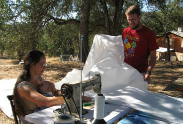 Sail Making Our sail loft was located under the big oak tree that shaded every other part of the boatbuilding project.