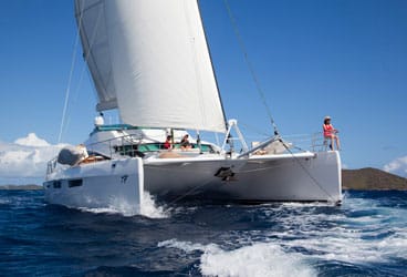 Luxury Charter Charity Guests and crew mingle on the generous foredeck of the 75-foot cat Matau as it sails the islands of St. Vincent and the Grenadines.