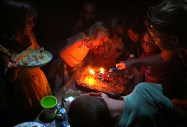 At Home Afloat, birthday Kids crowd around the beach party birthday cake.