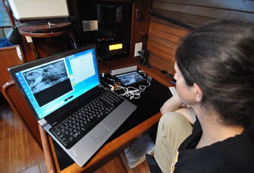 Del Viento- tech Here's my wife, the magician, at her nav station. "How have you gotten weather info previously?" some might ask. The answer is that since we started, we've nearly always had internet access available, at least prior to beginning a passage, and we've simply come this far by the grace of www.passageweather.com, and the buoy data at http://www.ndbc.noaa.gov/ --we've infrequently relied exclusively on VHF-broadcast weather, even when available.