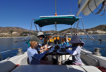 Del Viento- cockpit Southern California sailors are fortunate to have several mostly uninhabited islands, featuring beautiful and superb anchorages, just 15 to 30 miles offshore. Here we are enjoying French Toast in Smugglers Cove on Santa Cruz Island.