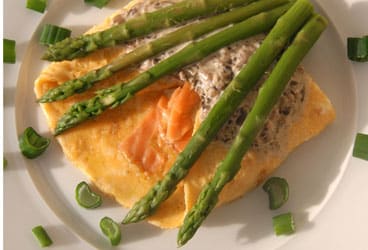 Omelette served with asparagus, salmon and green onion