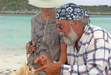 Jeremy Waters (right) teaches Kaeo Clarke how to make a conch horn on Salt Cay, in the Turks and Caicos Islands.