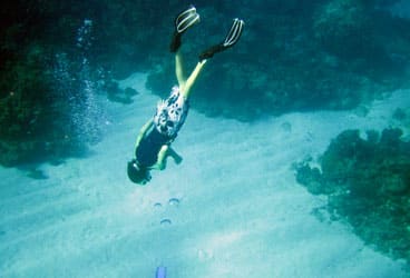 Kaeo Clarke free dives about 25 feet down to catch up with his sister, Kailani, who’s below him in scuba gear.