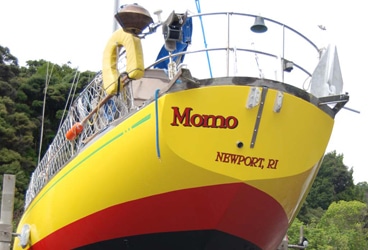 Painting Topsides Momo resplendent: Only yellow would be too yellow, so they added a fat red stripe and a thin green sheer stripe.