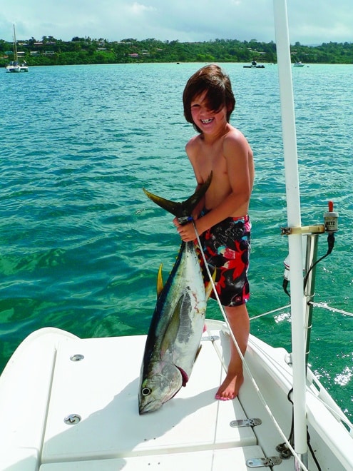 Ethan shows off a tuna near Scawfell Island. Fishing is allowed outside the protected zones of the Great Barrier Reef National Park.