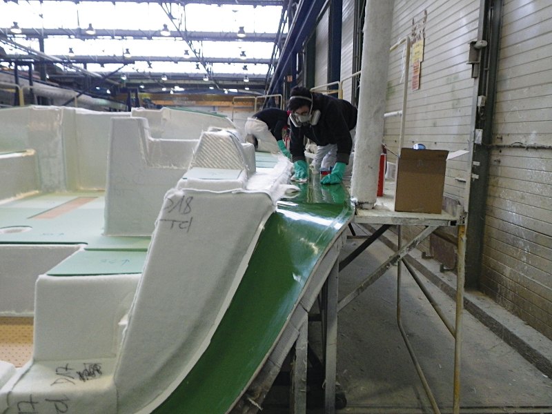 Building a Sandwich At Dufour Yachts, workers stack dry, precut fiberglass panels on a deck mold in preparation for its resin infusion. The layup includes a foam core, the green sheets of which you can see in the left of the photo.