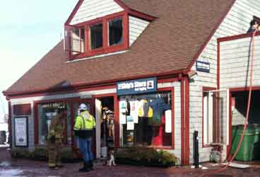 fire photo Firefighters and onlookers inspect the damage at Newport's waterfront marine store.