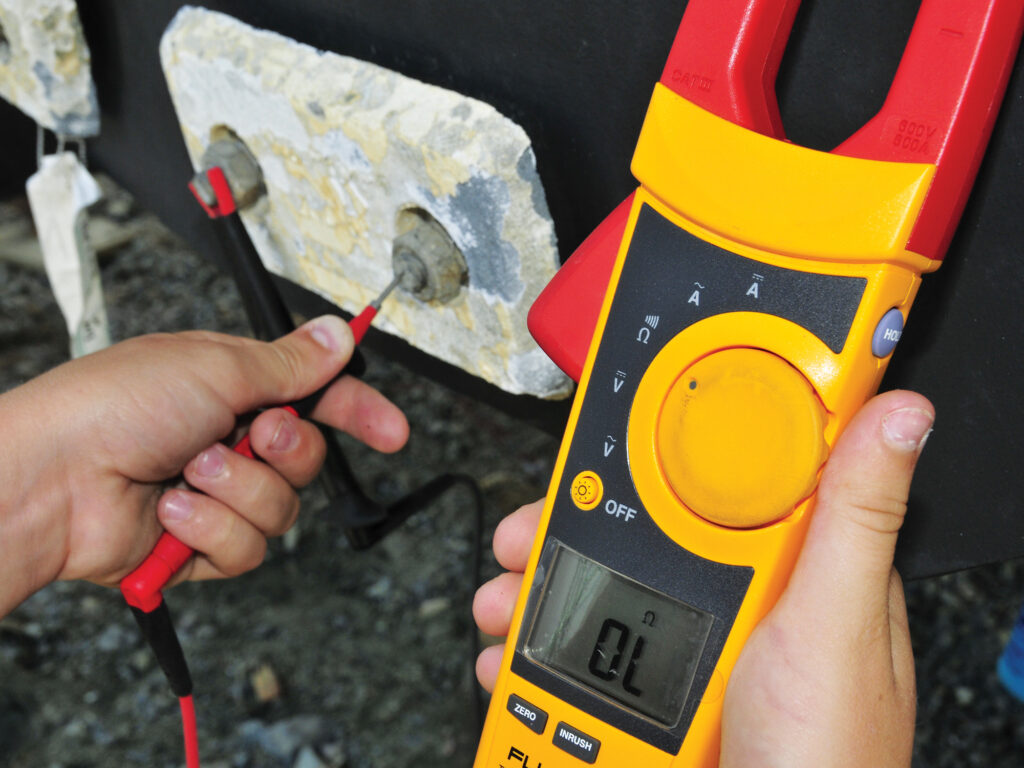 Digital multimeter testing a corroded connection
