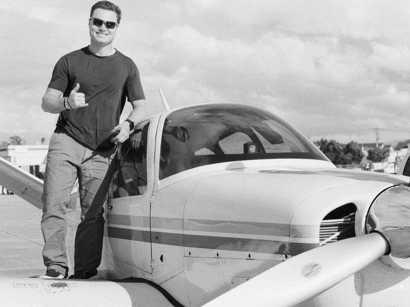 Man on the wing of a Bonanza plane