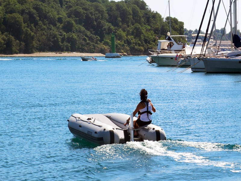Person on an dinghy with a RemigoOne Neo electric outboard motor