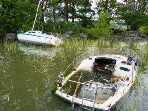 Two abandoned sailboats sit in shallow water in Lake Malaren.