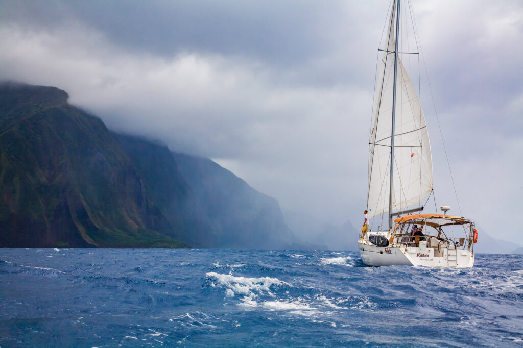 Beneteau 473 sails beneath Molokai’s towering sea cliffs
