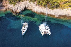 AdobeStock_376546099 Anchored sailboat and catamaran