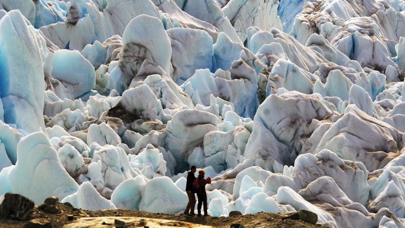 People standing in front of a glacier