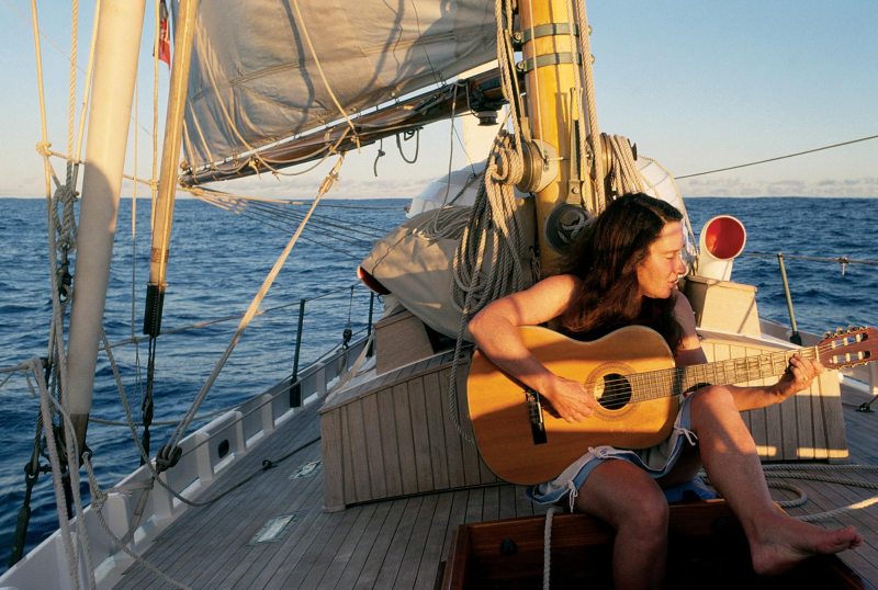 Sailor playing guitar on sailboat deck