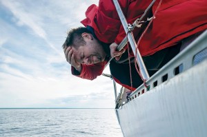 Man leaning over the side of a boat