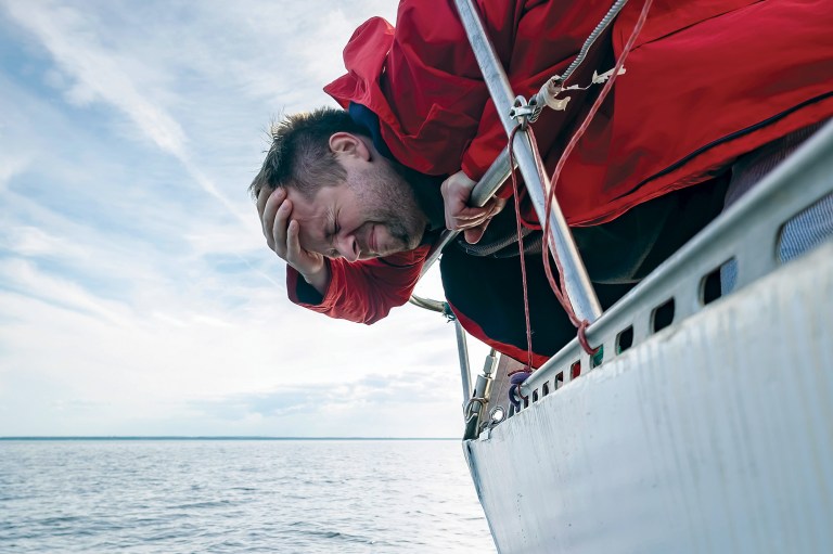 Man leaning over the side of a boat
