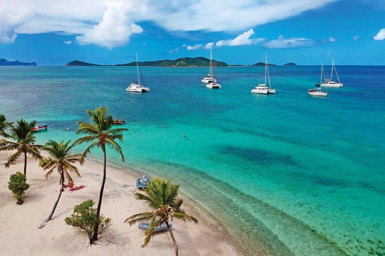 Aerial view of Petit Rameau tropical Caribbean Island beach, sailing catamarans and boats